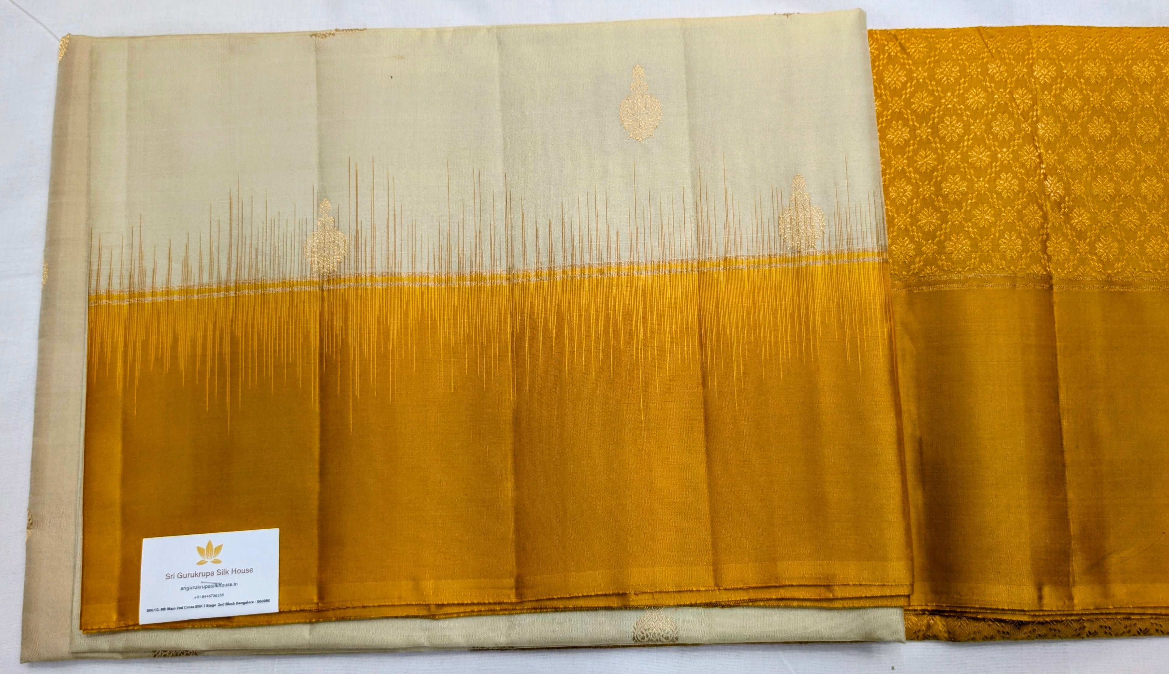 Yellow and beige fabric with a visible brand label on a white background